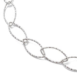 zoomed in section of silver tone textured horse eye link necklace on white background. 