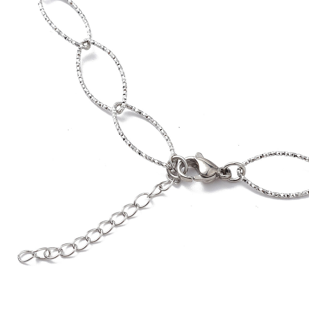 zoomed in section of silver tone textured horse eye link necklace with lobster claw clasp and extender chain on white background. 