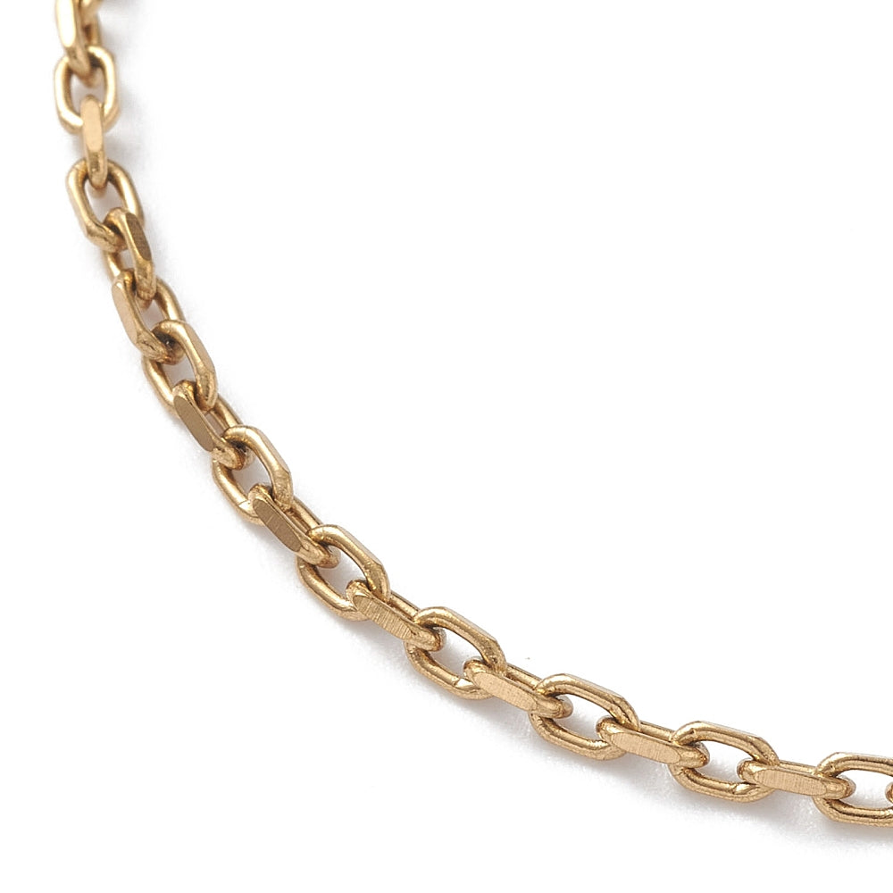 zoomed in section of golden cable chain bracelet over white surface. 