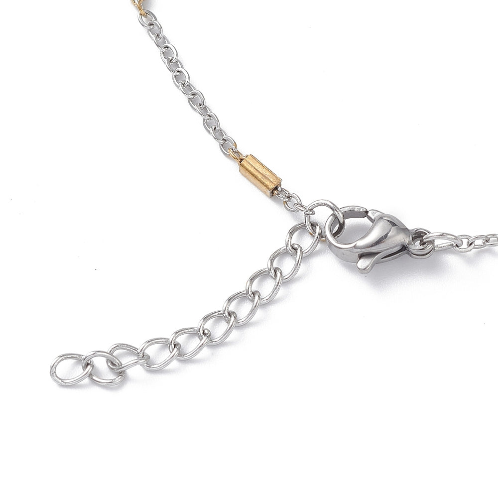 zoomed in sections of silver tone satellite chain bracelet with golden bar stations a lobster claw clasp and extender chain over white background. 