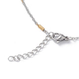 zoomed in section of silver tone lobster claw clasp and extender chain on cable and golden bar link satellite chain over white background. 