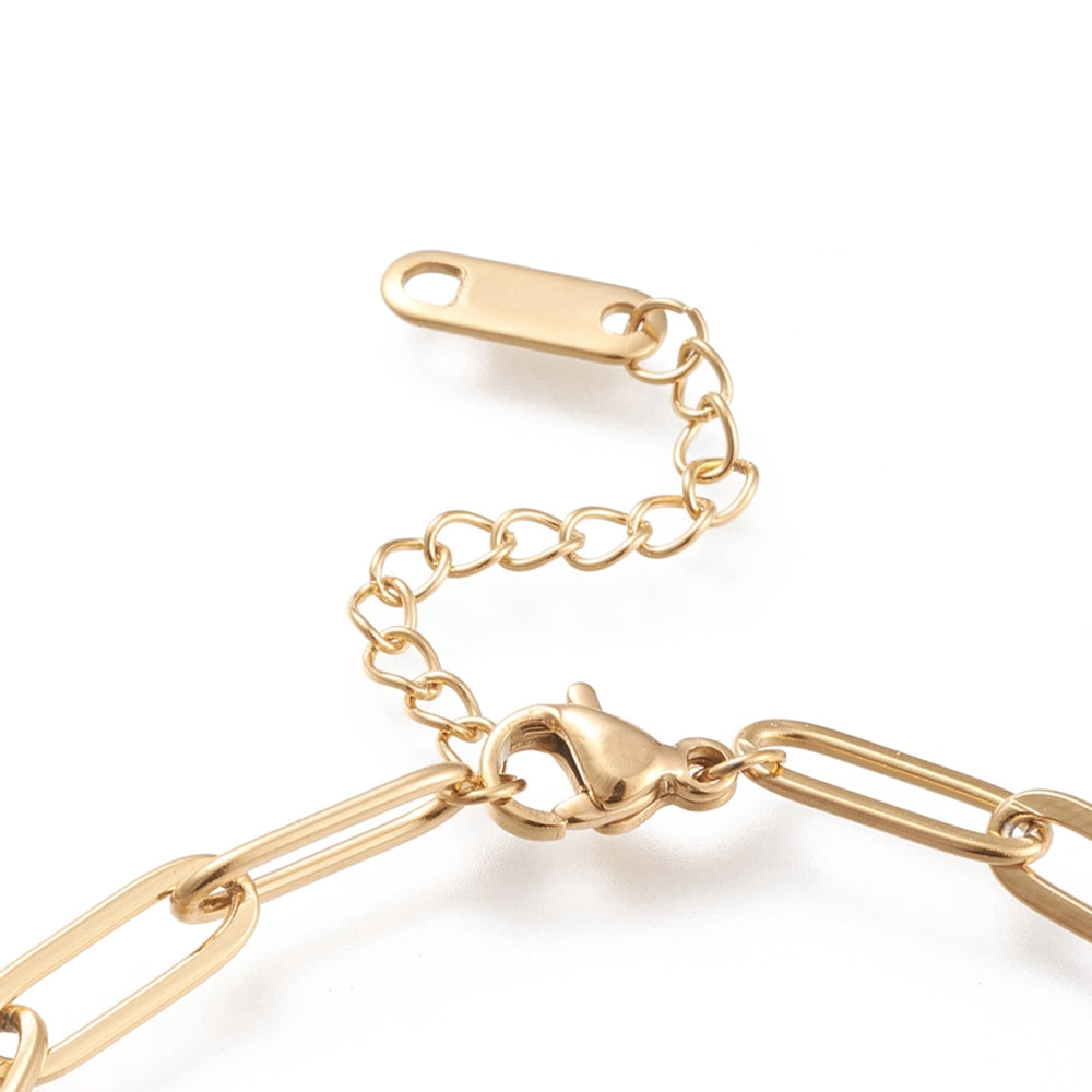 zoomed in section of golden lobster claw clasp and extender chain on paperclip chain over white background. 