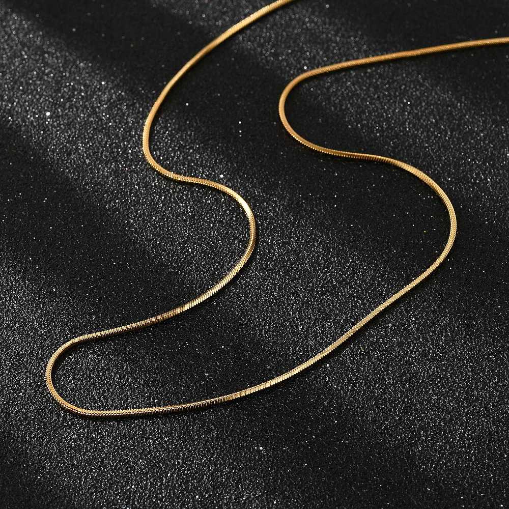 golden square snake chain necklace on black textured background. 