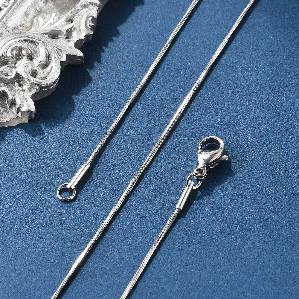 silver tone square snake chain with lobster claw clasp on blue felt background. 