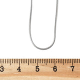 silver tone square snake chain displayed above wooden ruler on white background. 
