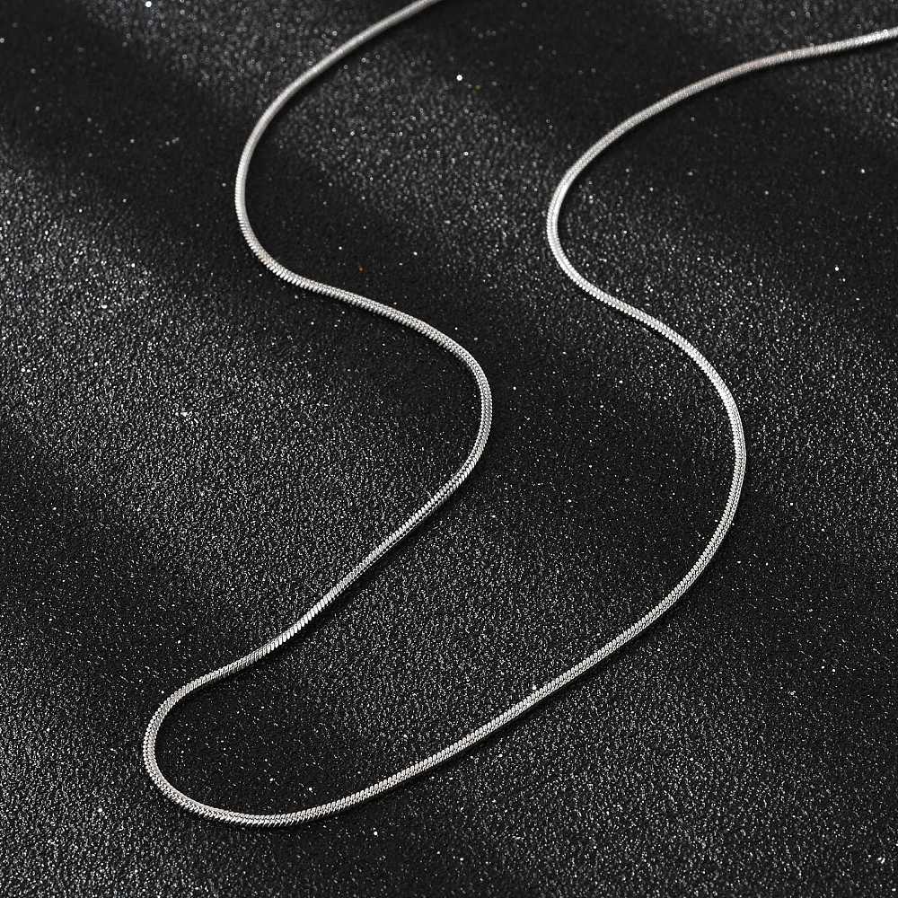 silver tone square snake chain necklace on black textured background. 