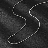 silver tone square snake chain necklace on black textured background. 