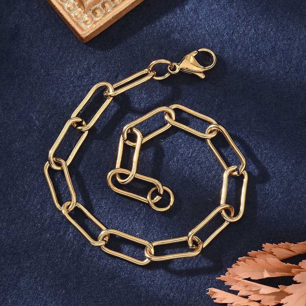 golden rounded paperclip chain bracelet with lobster claw clasp on blue felt background. 