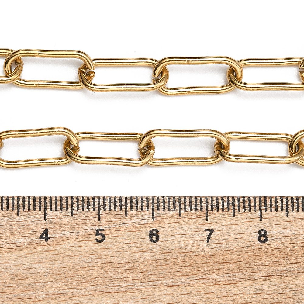 golden rounded paperclip chain displayed above a wooden ruler on white background. 