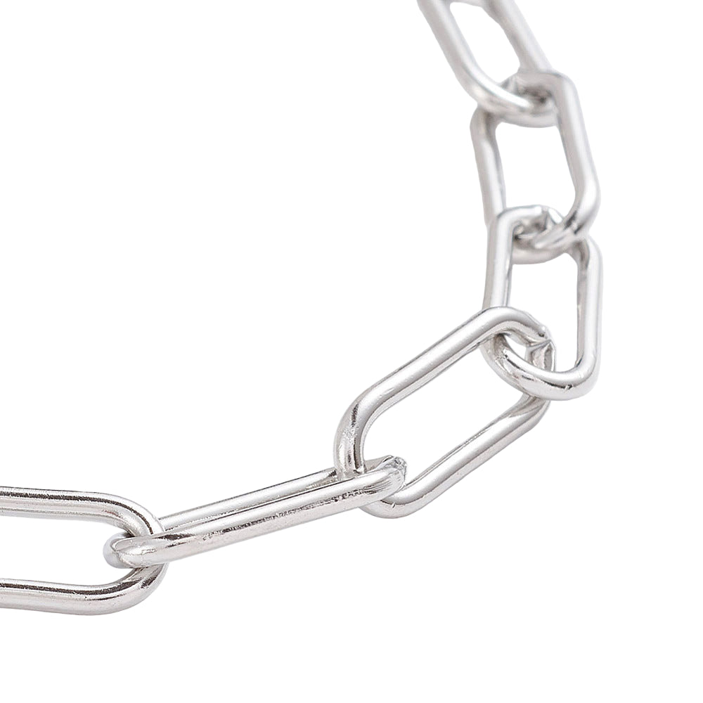 zoomed in section of golden rounded paperclip chain bracelet on white background. 