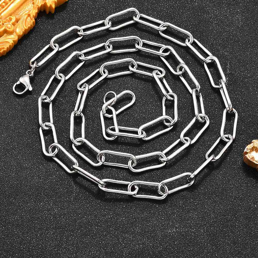 silver tone rounded paperclip chain necklace with lobster claw clasp on black textured background. 