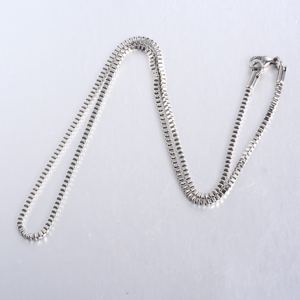 silver tone box chain necklace on white background. 