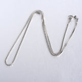 silver tone box chain necklace on white background. 