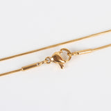 zoomed in sections of golden snake chain with lobster claw clasp on white background. 