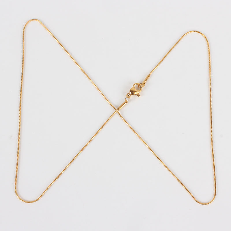 golden snake chain with lobster claw clasp on white background. 