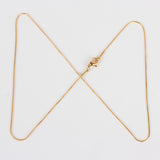 golden snake chain with lobster claw clasp on white background. 