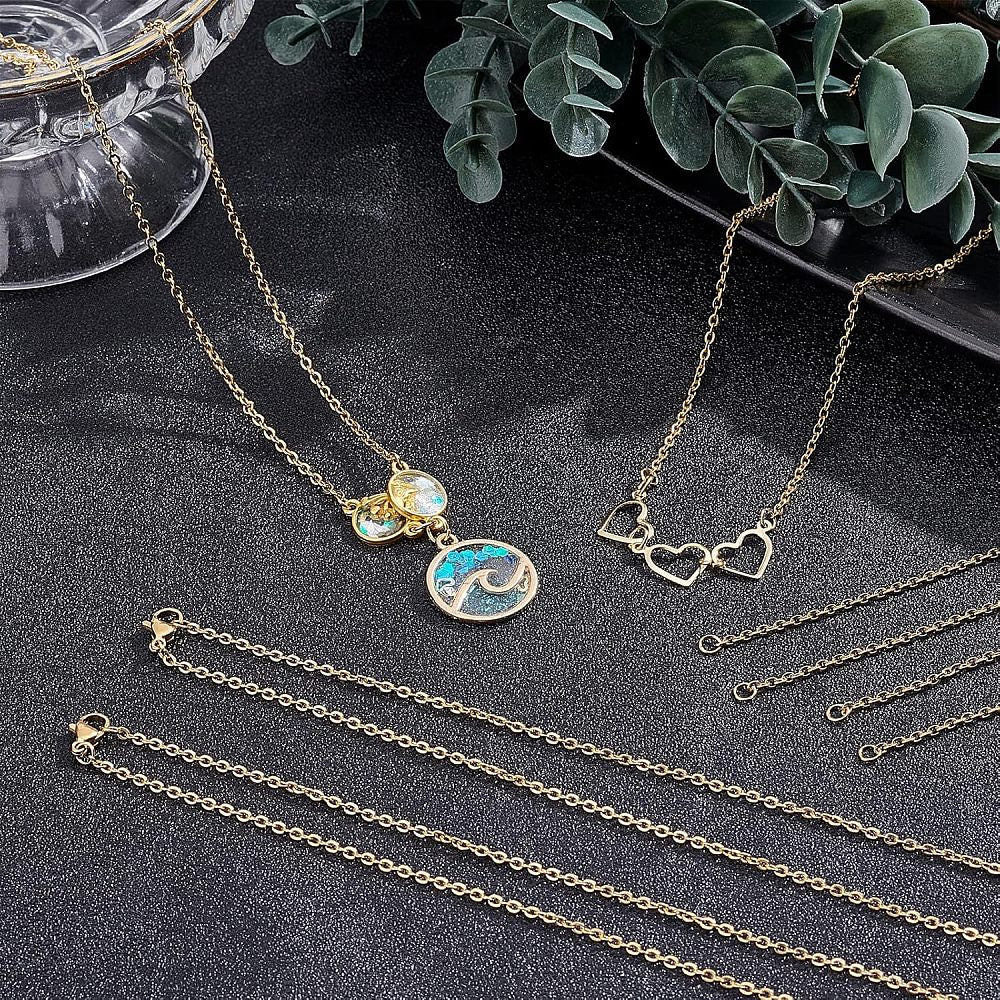 multiple golden cable chain necklaces displayed against a black textured background showing the chain as is or with circular or heart connector charms installed. 