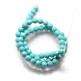 light blue turquoise dyed Howlite faceted round bead strand over white background. 
