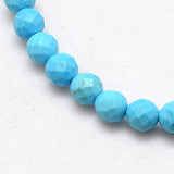 zoomed in section of blue turquoise dyed Howlite faceted round bead strands over white background. 