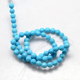 blue turquoise dyed Howlite faceted round bead strand over white background. 
