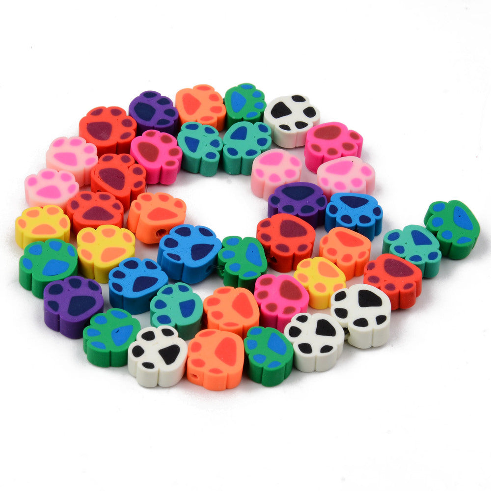 colorful handmade polymer clay animal paw print bead strand in swirl design over white background. 
