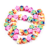 colorful handmade polymer clay fish bead strand in swirl design over white background. 
