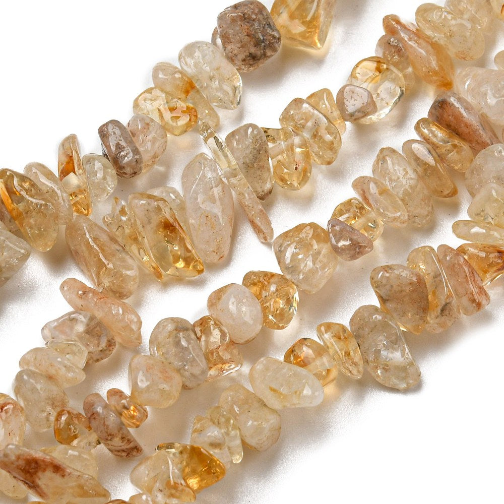 four citrine chip bead strands over white surface. 