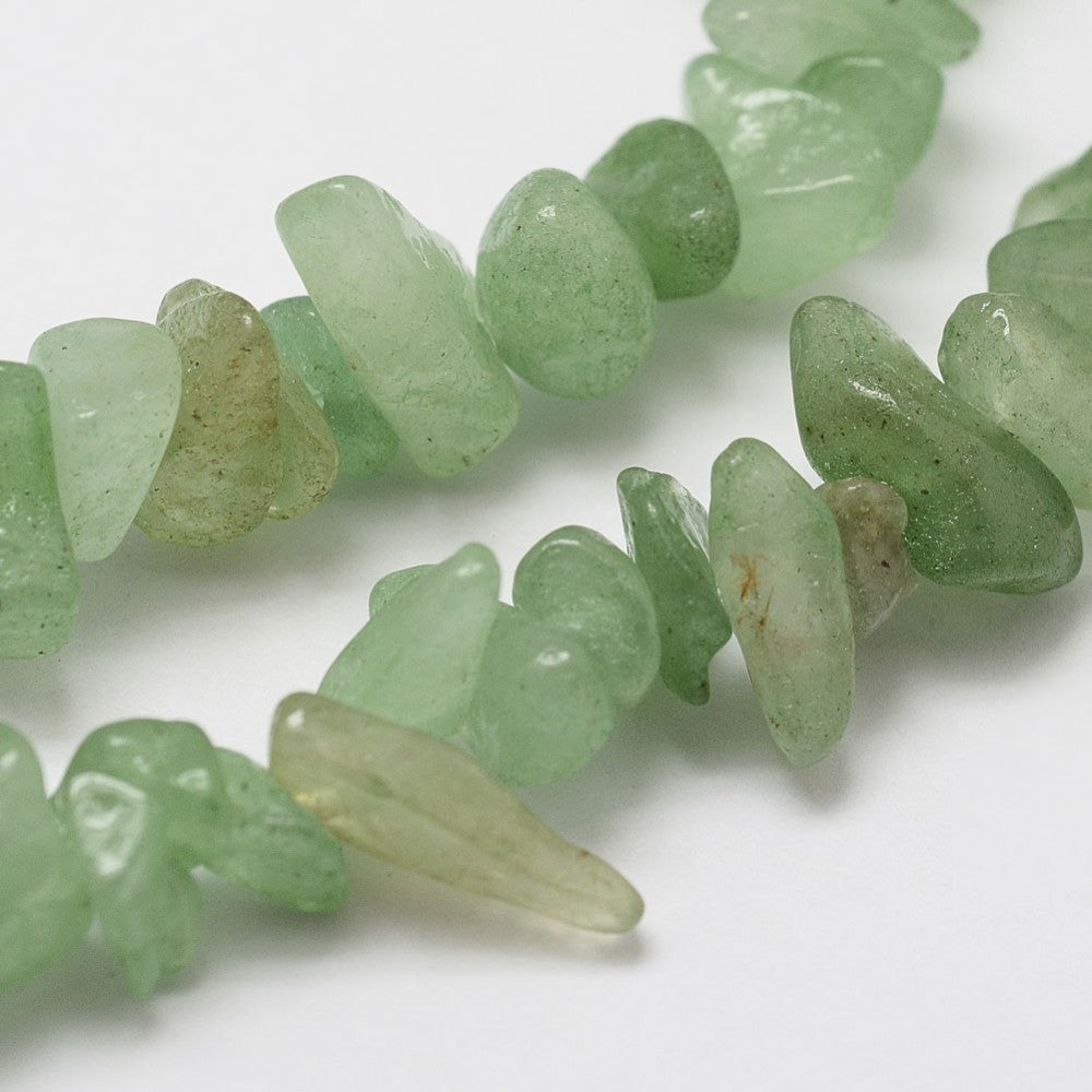 zoomed in sections of green aventurine chip bead strands over white background. 