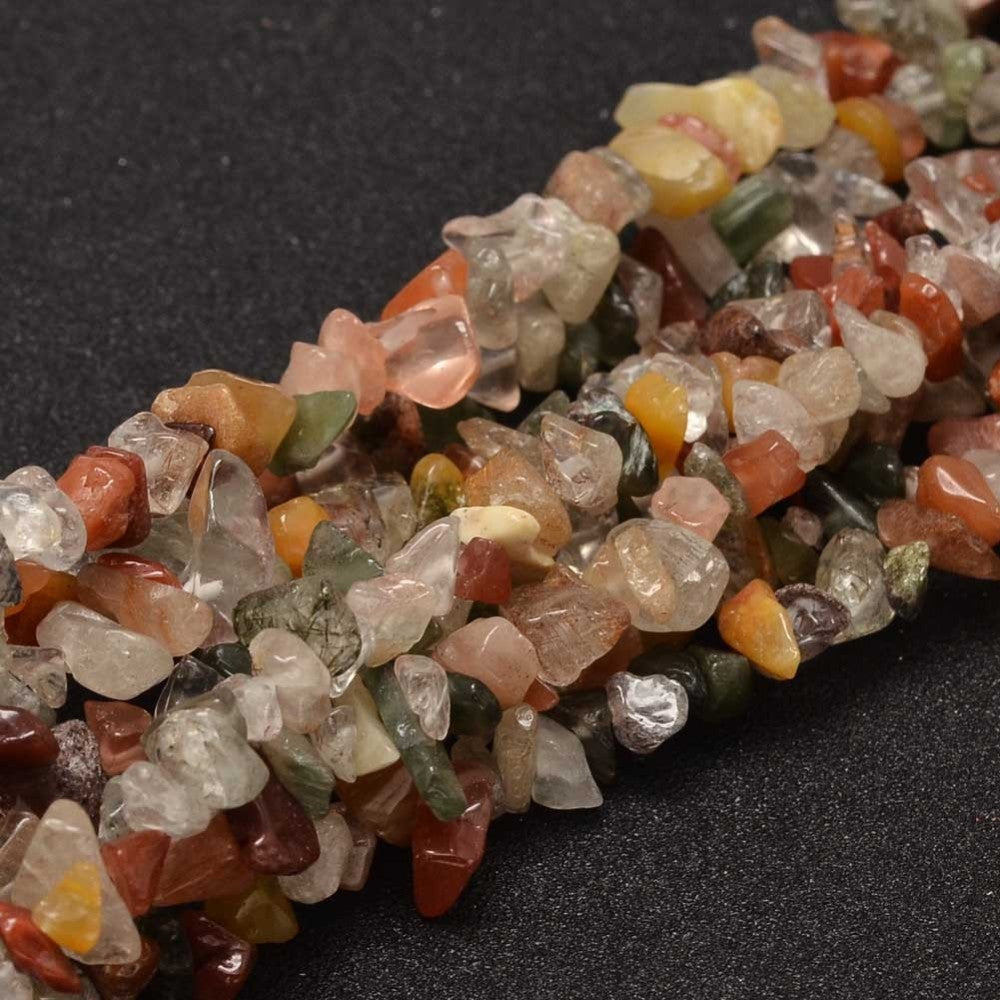 multiple strands of multi-color rutilated quartz chip beads over black surface. 