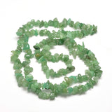 green aventurine chip bead strand in swirl design over white background. 