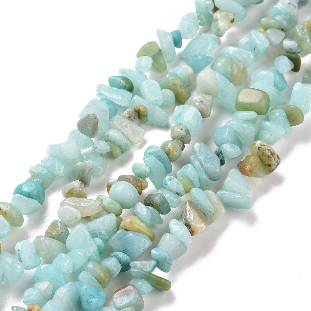 zoomed in sections of natural flower amazonite chip bead strands over white surface. 
