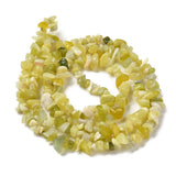 lemon jade chip bead strand in swirl design over white surface. 