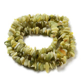 lemon jade chip bead strand in swirl design over white surface. 
