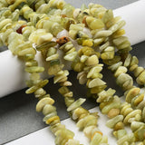 six lemon jade chip bead strands draped over white cylinder onto grey and white surface. 