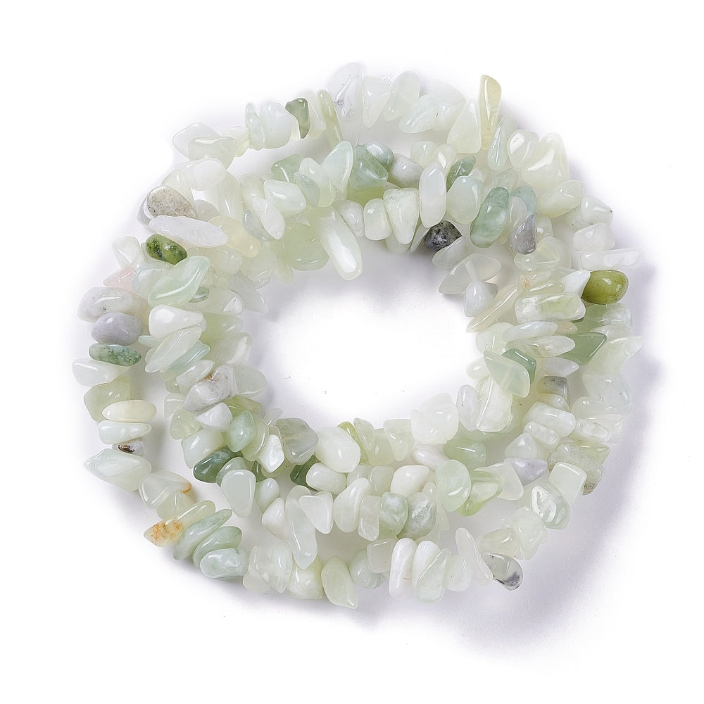 new jade chip bead strand in swirl design over white surface. 
