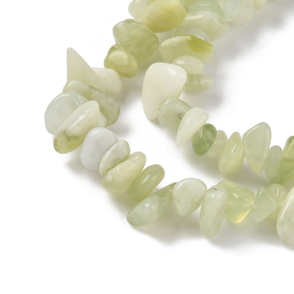 zoomed in sections of new jade chip bead strands over white surface. 