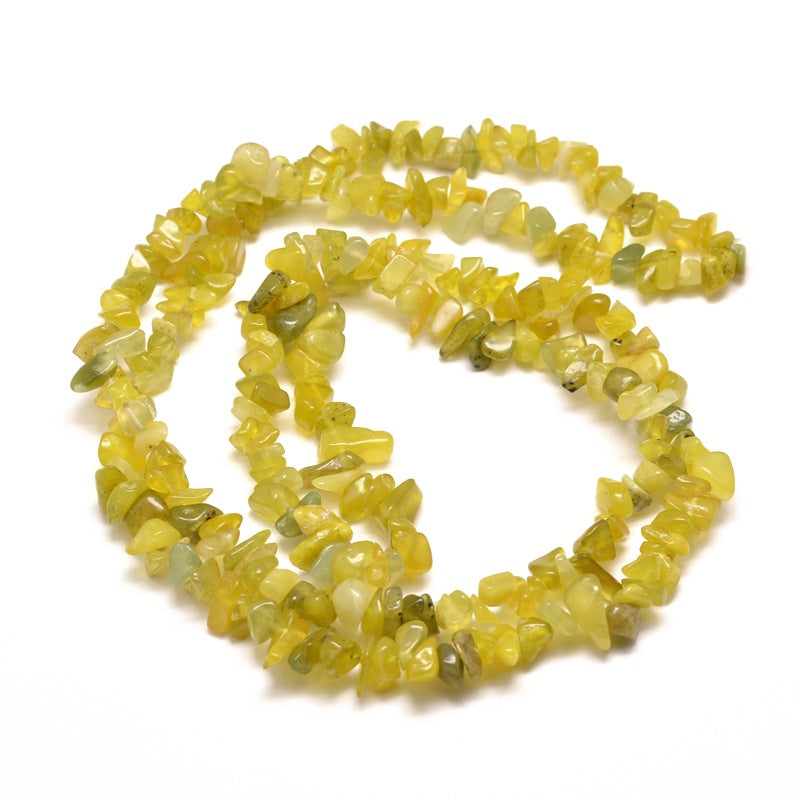 olive jade strand in swirl design over white surface. 