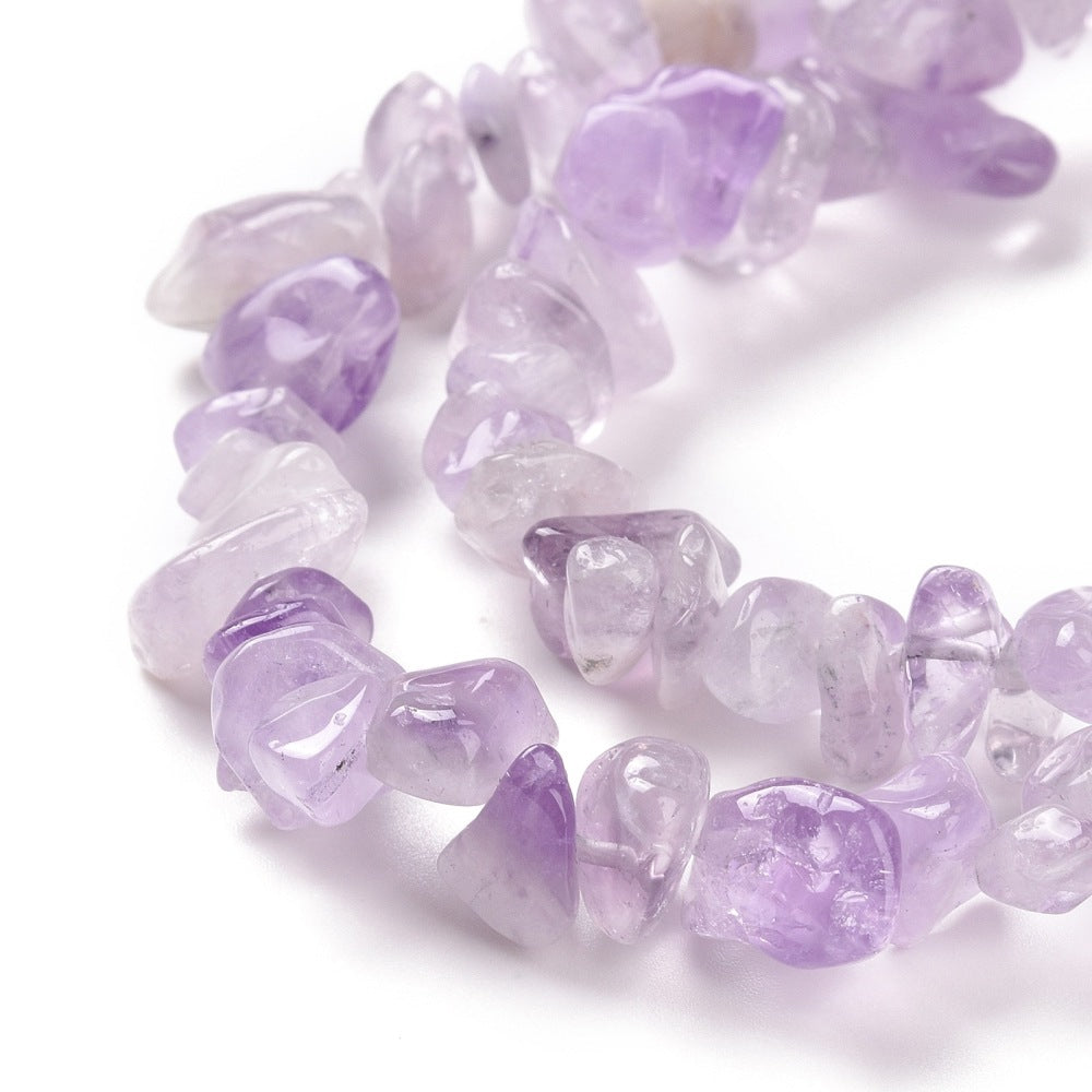 zoomed in sections of lavender amethyst chip bead strands over white background. 