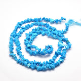 dyed light sky blue synthetic turquoise chip bead strand in a swirl design over white surface. 