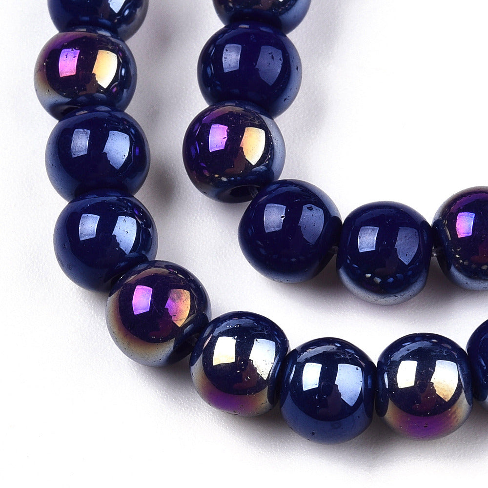 zoomed in sections of iridescent blue glass bead strand over white surface.  