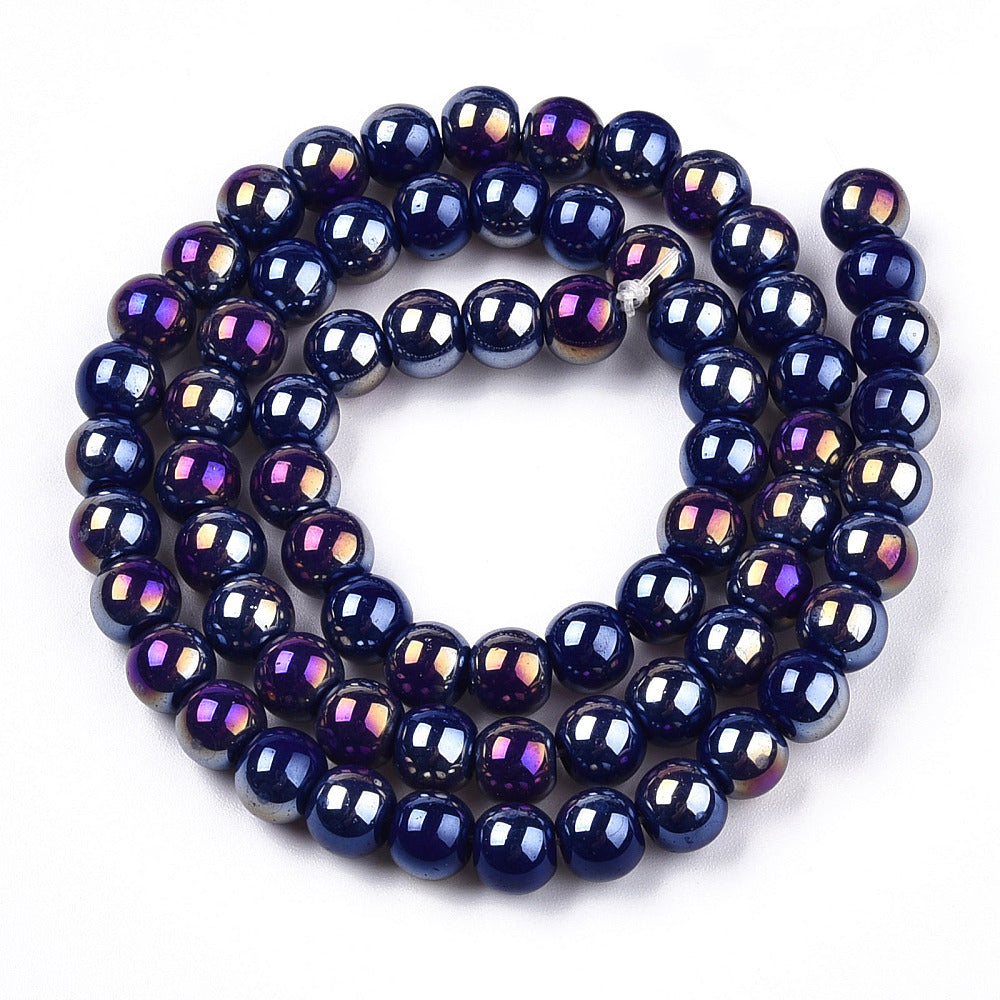 iridescent blue glass bead strand in swirl design over white surface.  