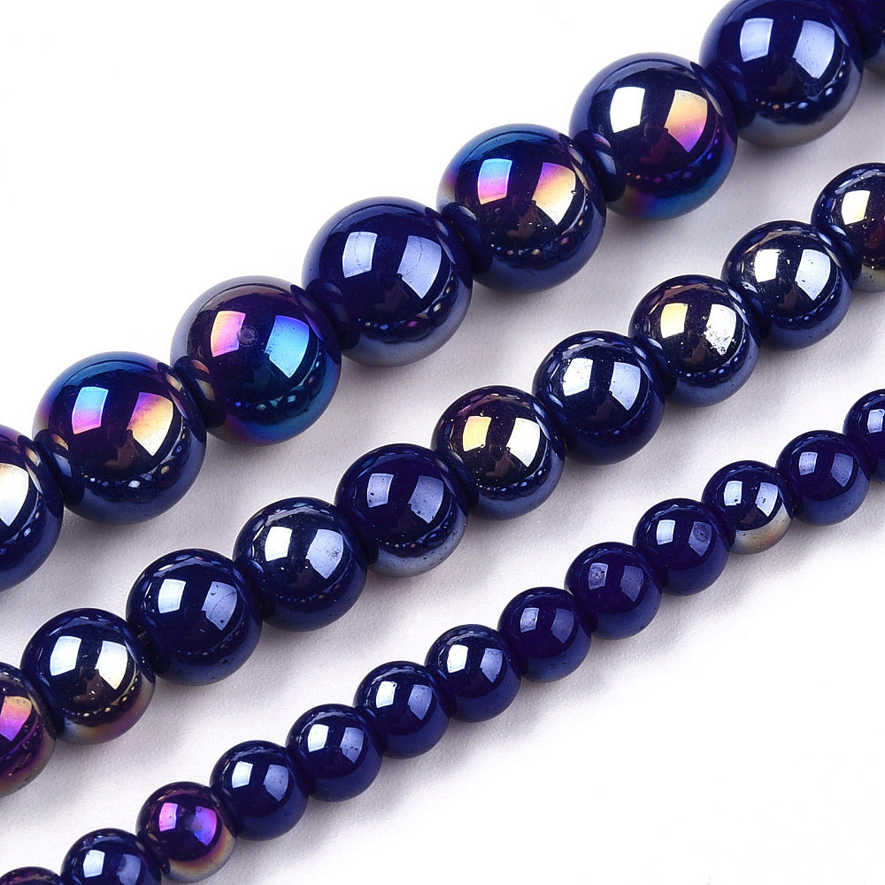 zoomed in sections of three different size iridescent blue glass bead strands over white surface.  
