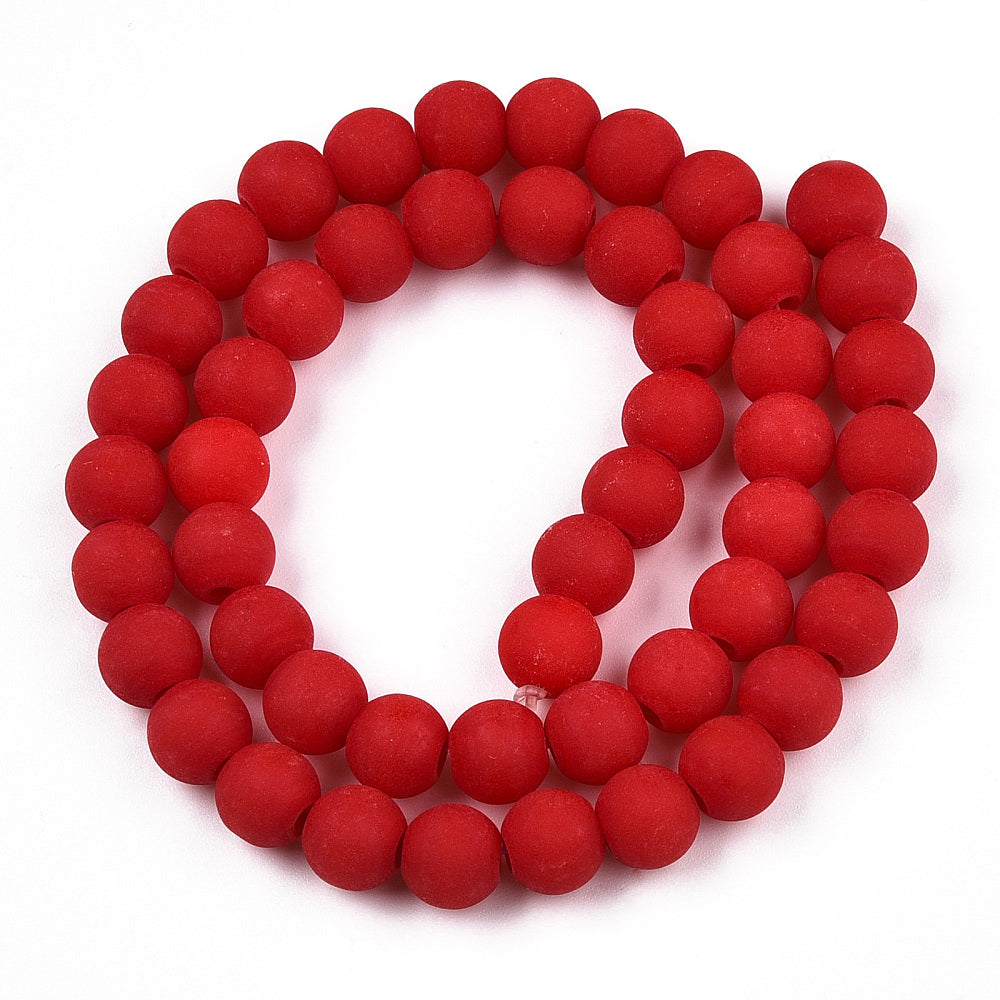 four matte frosted red opaque round glass beads in swirl design over white background. 