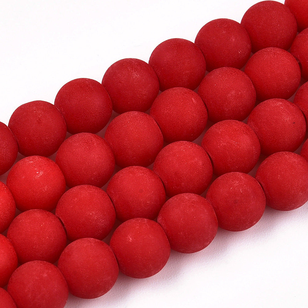 four matte frosted red opaque round glass beads over white background. 
