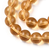 zoomed in sections of champagne colored round glass bead strands over white surface. 