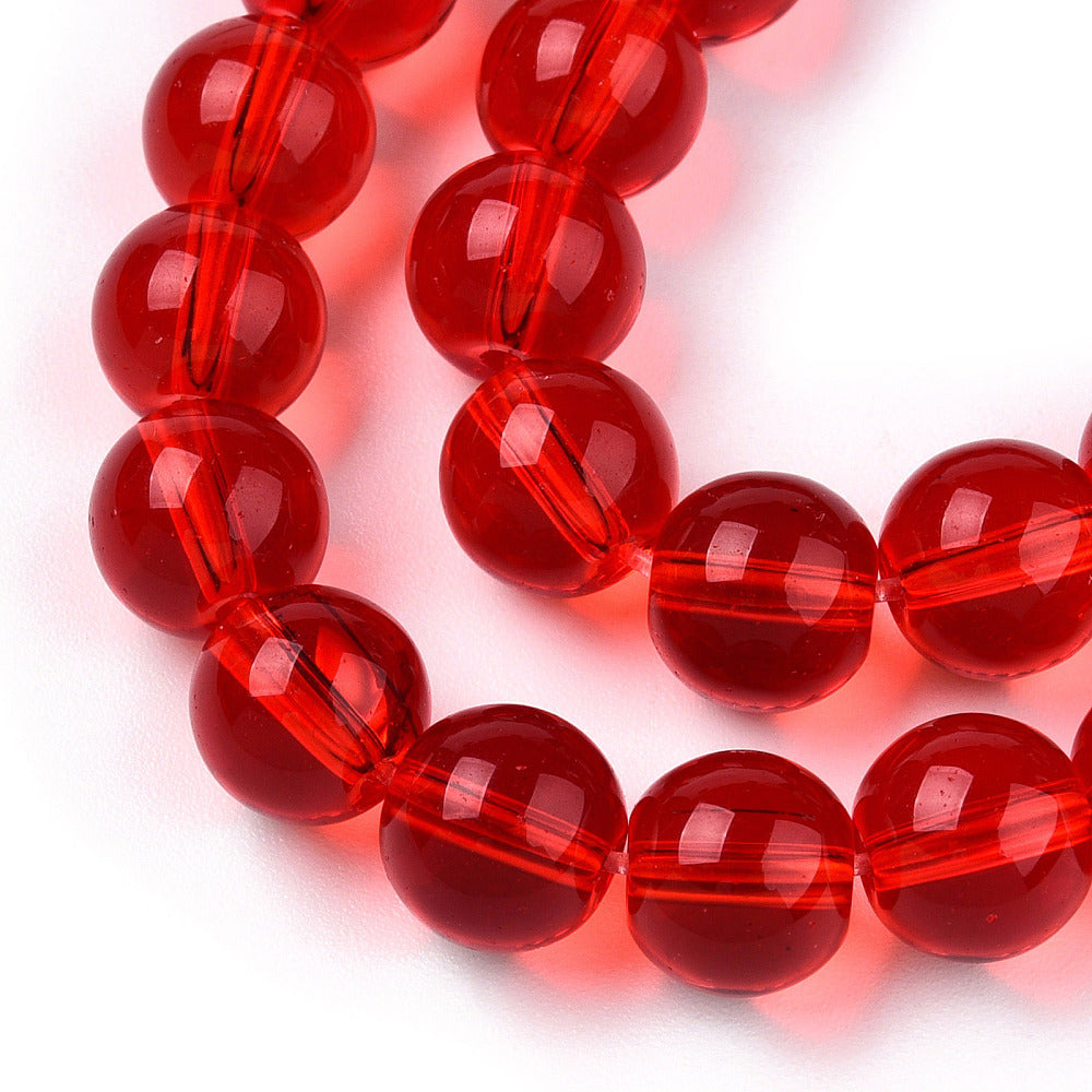 zoomed in section of four translucent red round glass bead strands over white background. 