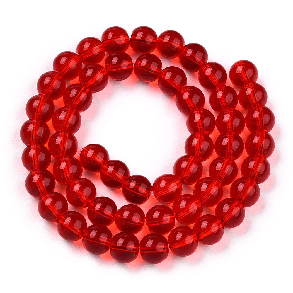 translucent red round glass bead strand in swirl design over white background. 