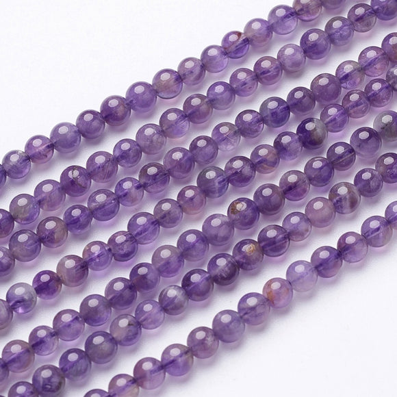 seven strands of smooth round amethyst beads over white background. 