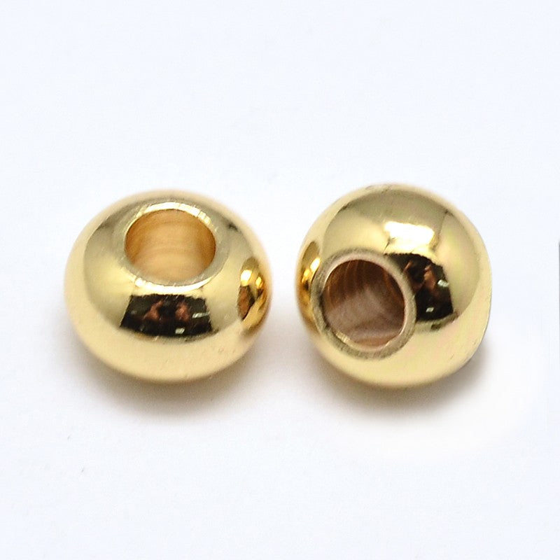 two light golden smooth rondelle spacer beads over white background. 