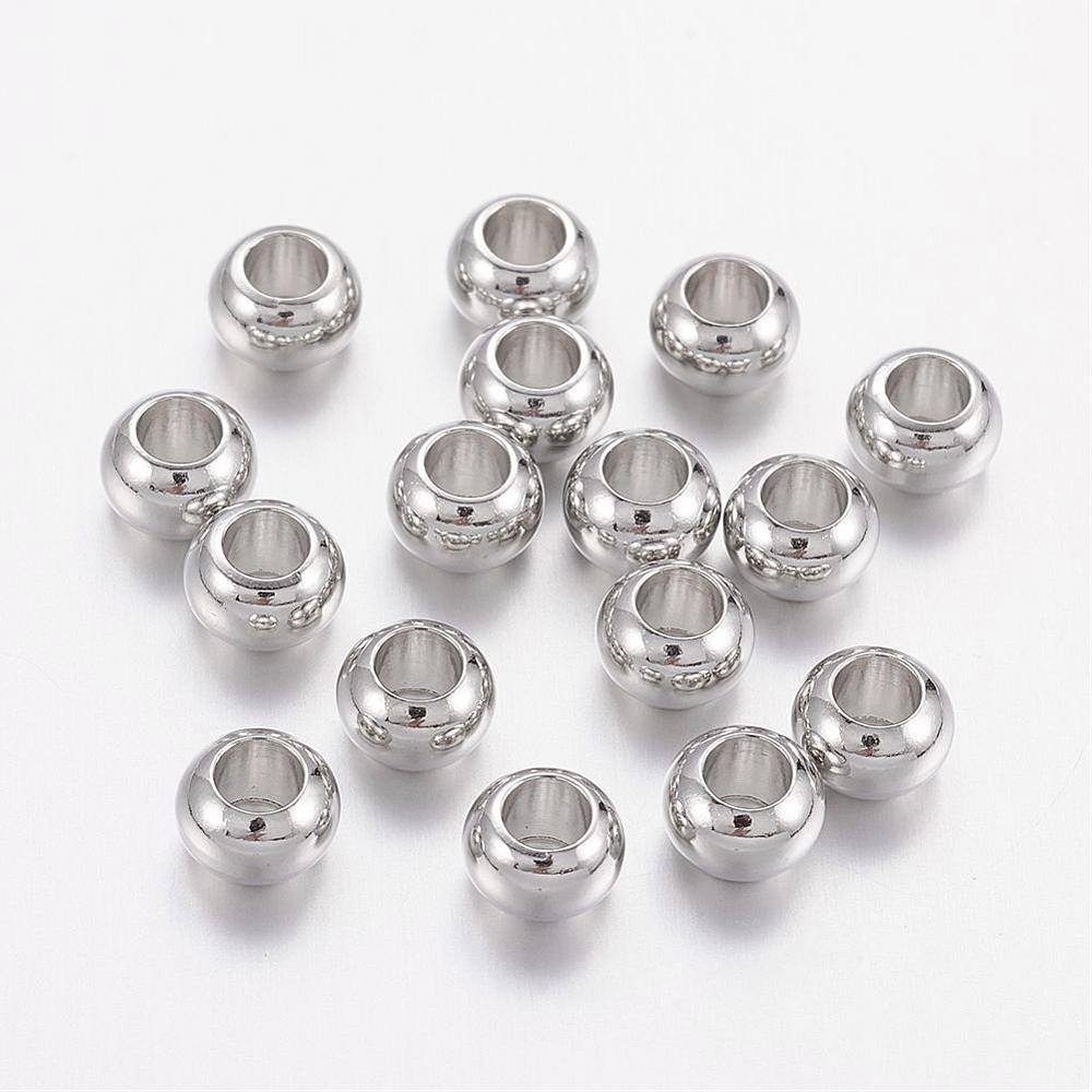 pile of silver tone smooth rondelle spacer beads over white background. 